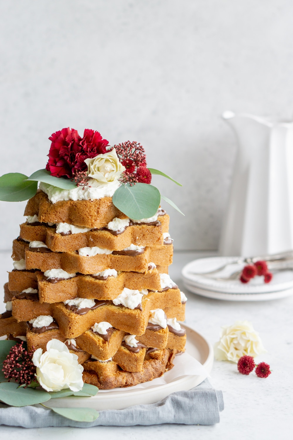 Pandoro Christmas tree cake with flowers on top and a vase in the background