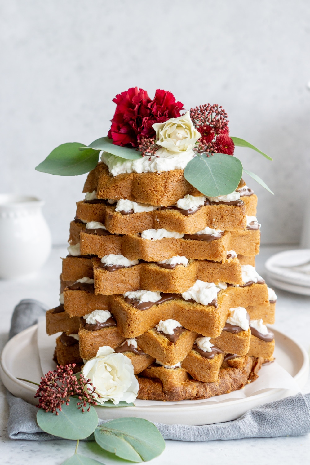 Pandoro christmas tree cake with nutella topped with fresh flowers