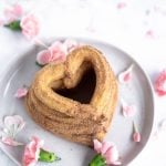 heart shaped churros stacked on a plate with pink flowers
