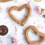 overhead shot of three heart churros with pink flowers