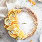 Pastiera napoletana decorated with fresh oranges, lemon and white flowers