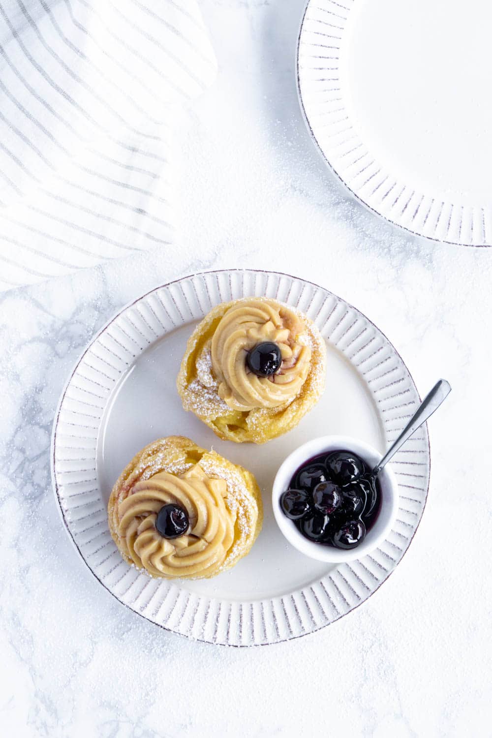 Italian Zeppole di San Giuseppe - Saint Joseph's Day fritters. So delicious!! #pinacooks #zeppoledisangiuseppe #italiandesserts overhead shot of zeppole di San Giuseppe on a plate