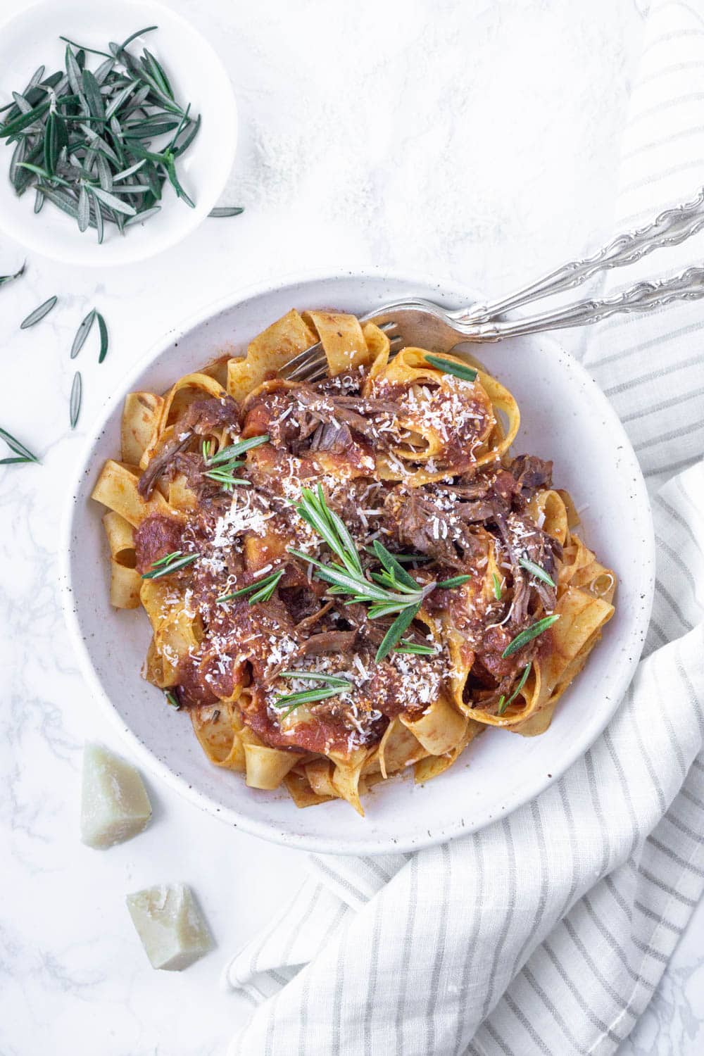 Short Rib Ragu Recipe: Such a rich and delicious sauce! #italianfood #italianrecipes #pastarecipes #shortribragu #pinacooks pappardelle with beef short rib ragu in a plate topped with rosemary