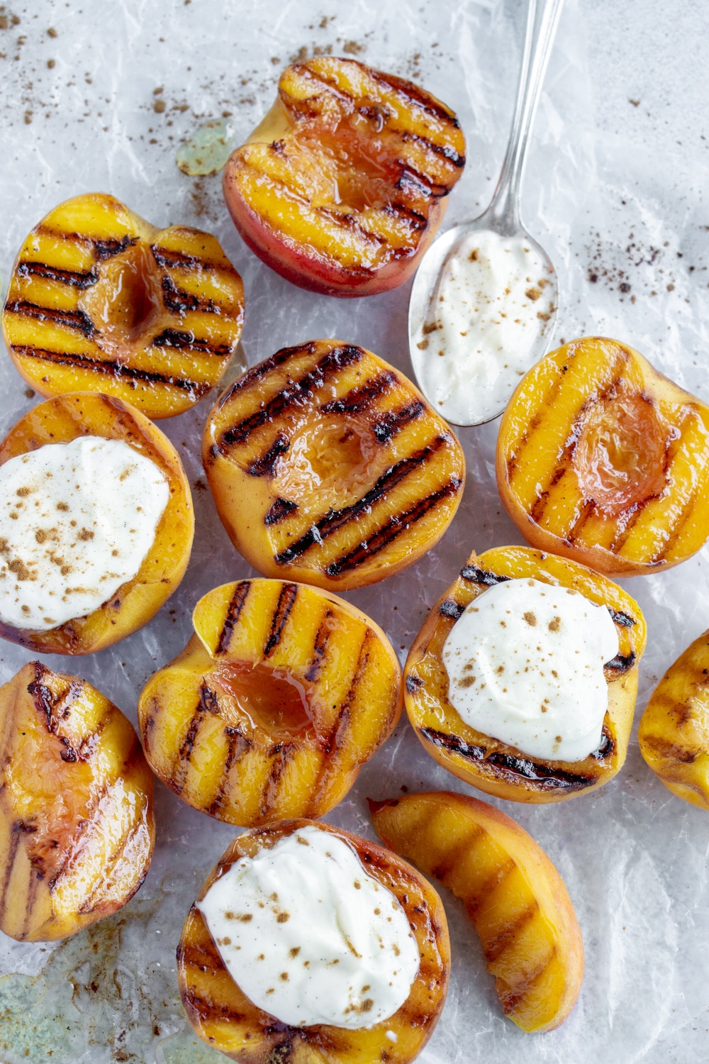 Grilled in the cast iron pan, these peaches with ricotta, honey and cinnamon are the perfect summer dessert! #pinacooks #grilledpeaches #summerdesserts Overhead shot of grilled peaches topped with ricotta