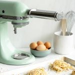 KitchenAid mixer with pasta attachment with homemade pasta in the foreground