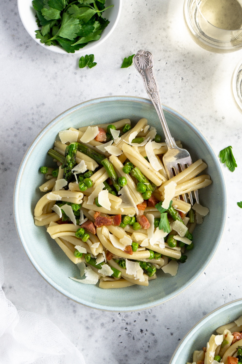 A pasta that only takes 30 minutes to make! Easy asparagus pasta with peas and pancetta. #pinacooks #asparaguspasta #italianrecipes Asparagus pasta overhead shot with 2 glasses of wine