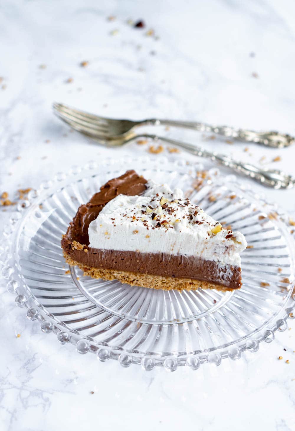 Slice of nutella tart on a glass plate with two forks