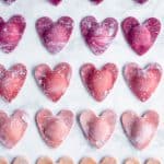 Overhead shot of ombré beet ravioli hearts on a marble background