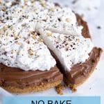 Side view of no bake nutella tart topped with whipping cream and one slice cut from the tart