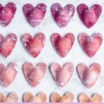 Overhead shot of ombré beet ravioli hearts on a marble background