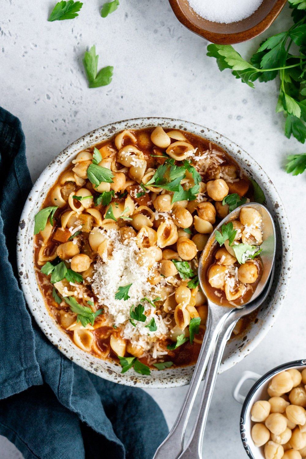 Overhead shot of a bowl of pasta e ceci with two spoons in it