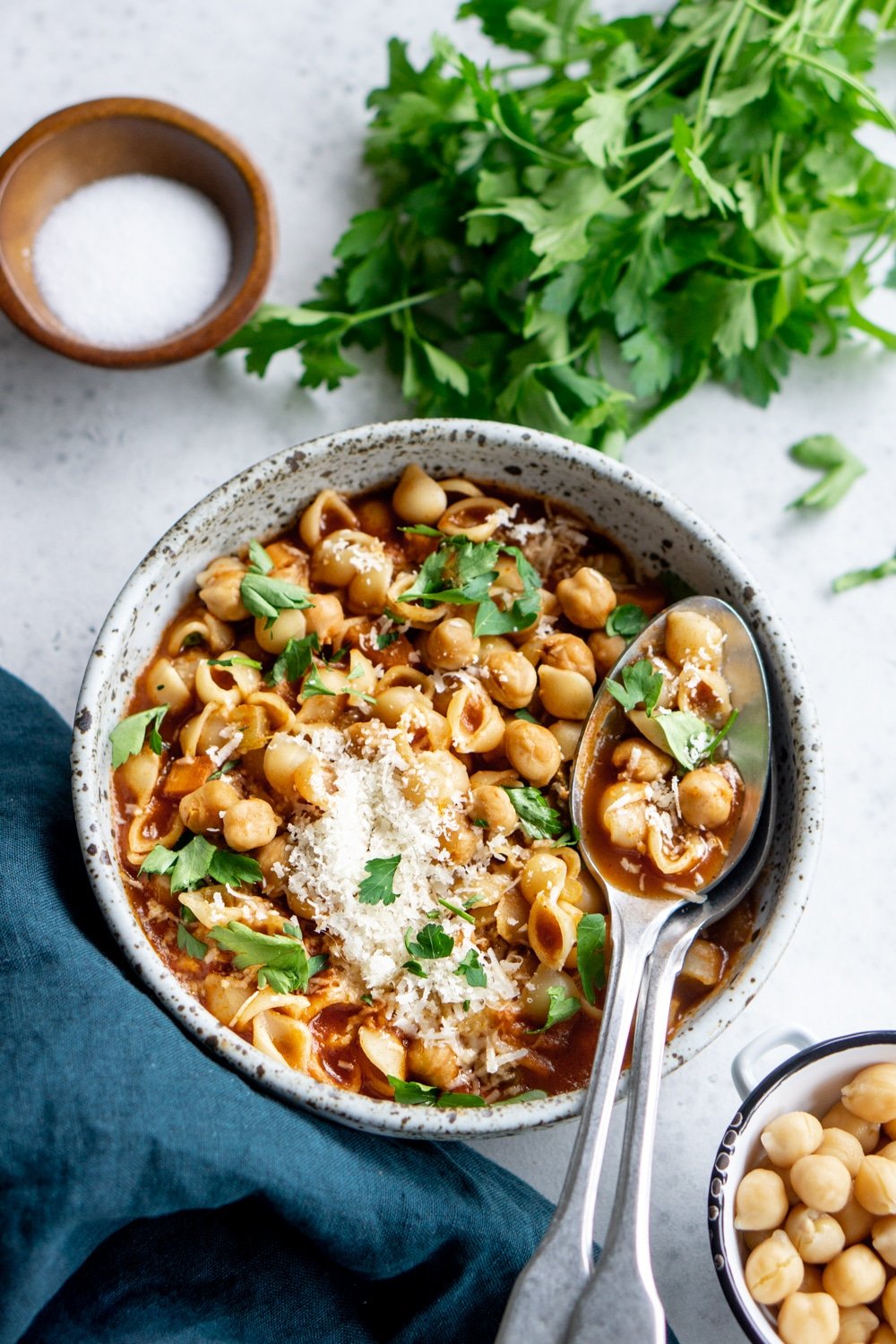 Bowl of chick pea soup with salt and parsley in the background