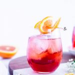 campari spritz in a glass garnished with an orange