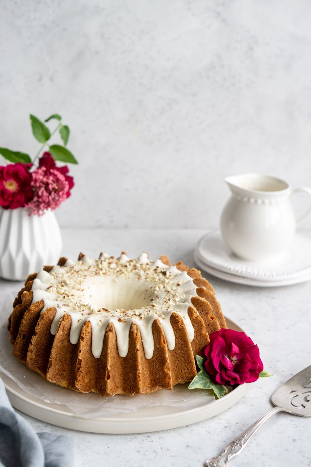 Homemade almond cake with amaretto glaze. Love the double almond flavors! #italianfood #italiandesserts #almondcake #pinacooks almond bundt cake on a plate with flowers in the background