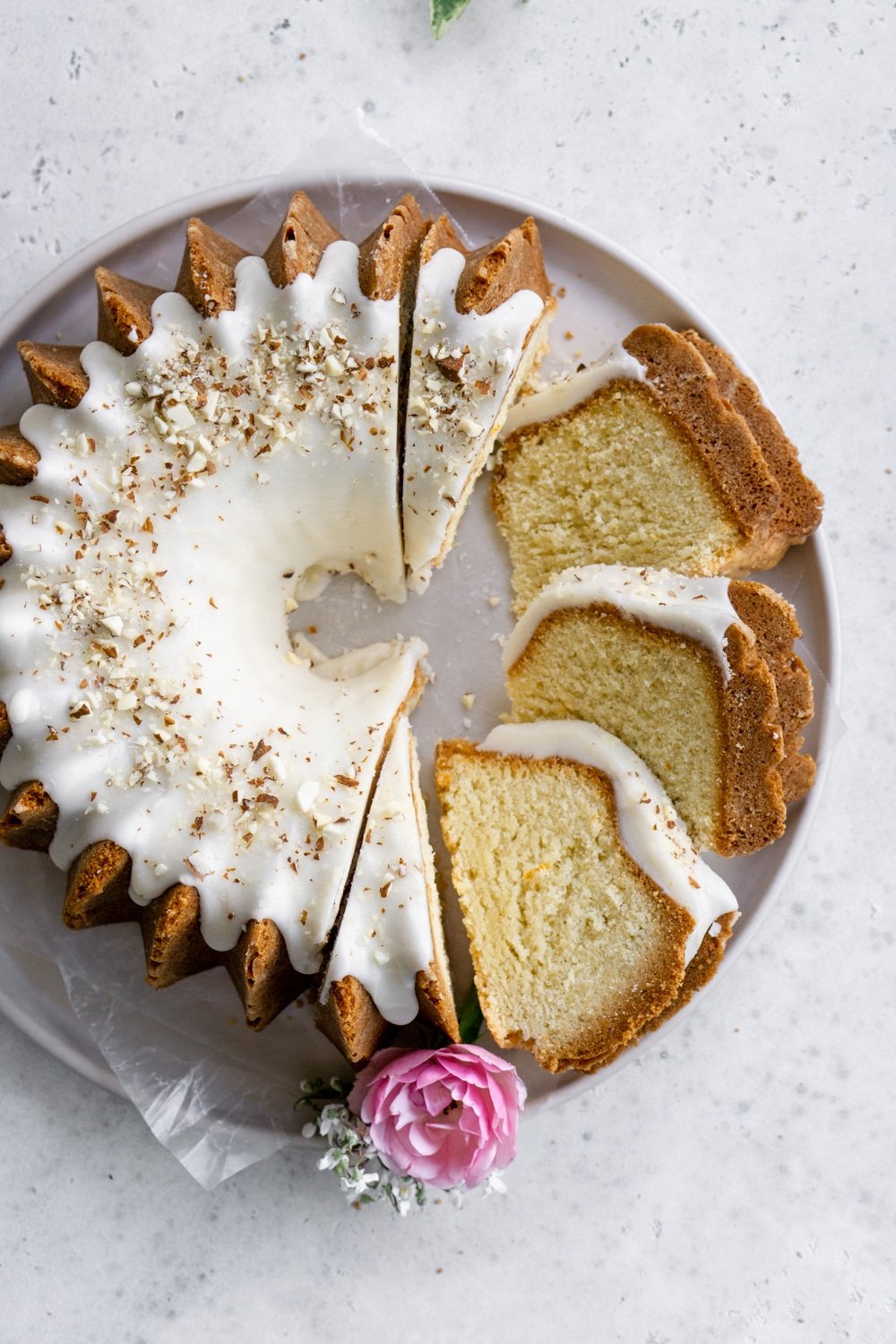 Love the beautiful Italian flavors in this cake! Easy almond cake recipe with amaretto glaze. #almondcake #italiandesserts #amarettodessert #pinacooks overhead view of almond cake on a plate with slices taken out