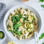 Ricotta pasta with zucchini and arugula in a plate with two forks
