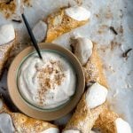 Cannoli cream in a bowl surrounded by cannoli