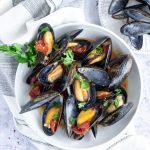 Plate of mussels sitting on a white napkin