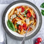 Bowl of pasta pomodoro sitting on top of two folded napkins