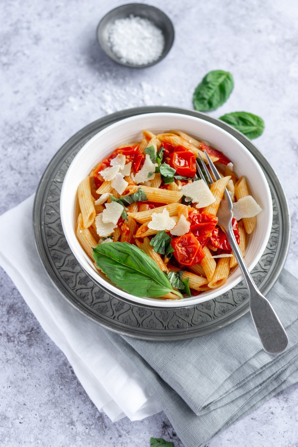 Pasta pomodoro - best when it's made with cherry tomatoes! Just follow this easy recipe. #pastapomodoro #italianfood #pinacooks Pasta pomodoro in a white bowl with basil leaves in the background