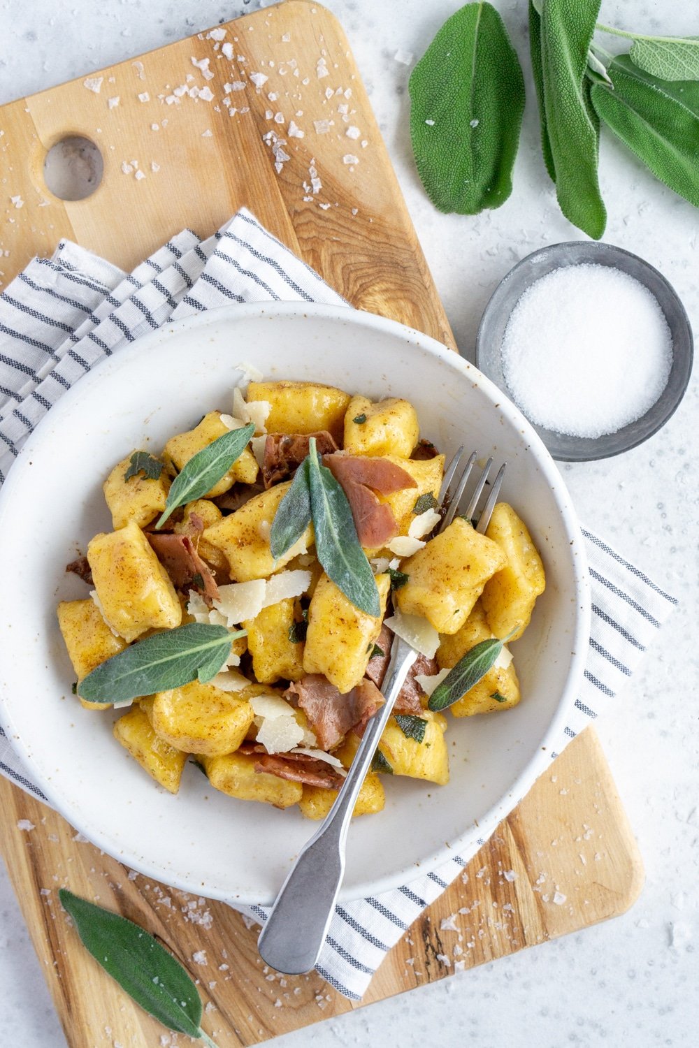 Delicious butternut squash gnocchi with brown butter, sage and prosciutto (no potato!) #butternutsquashgnocchi #italianrecipes #italianfood #pinacooks Butternut Squash gnocchi in a bowl on a cutting board