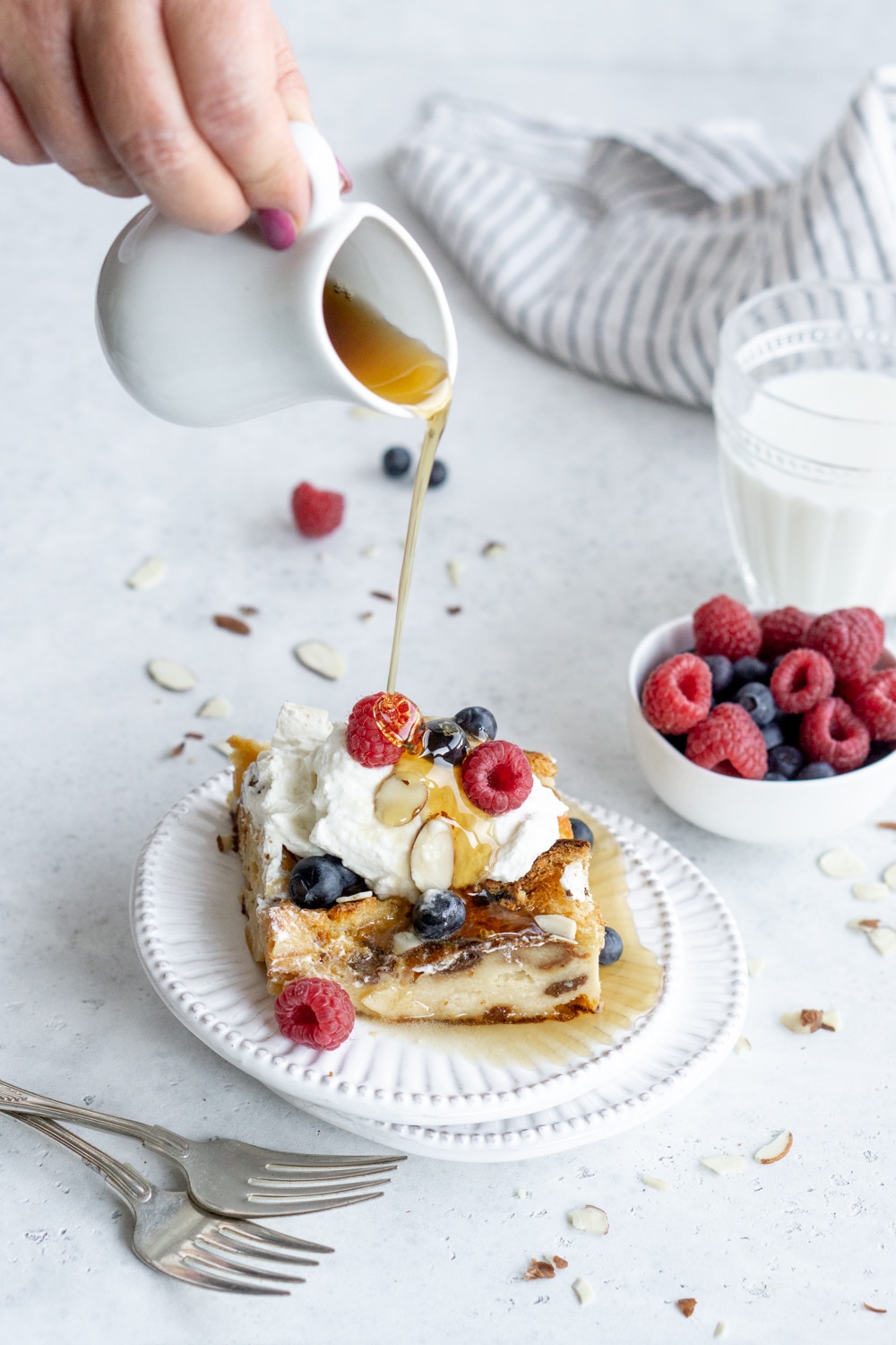 Slice of panettone bread pudding with maple syrup being poured on it