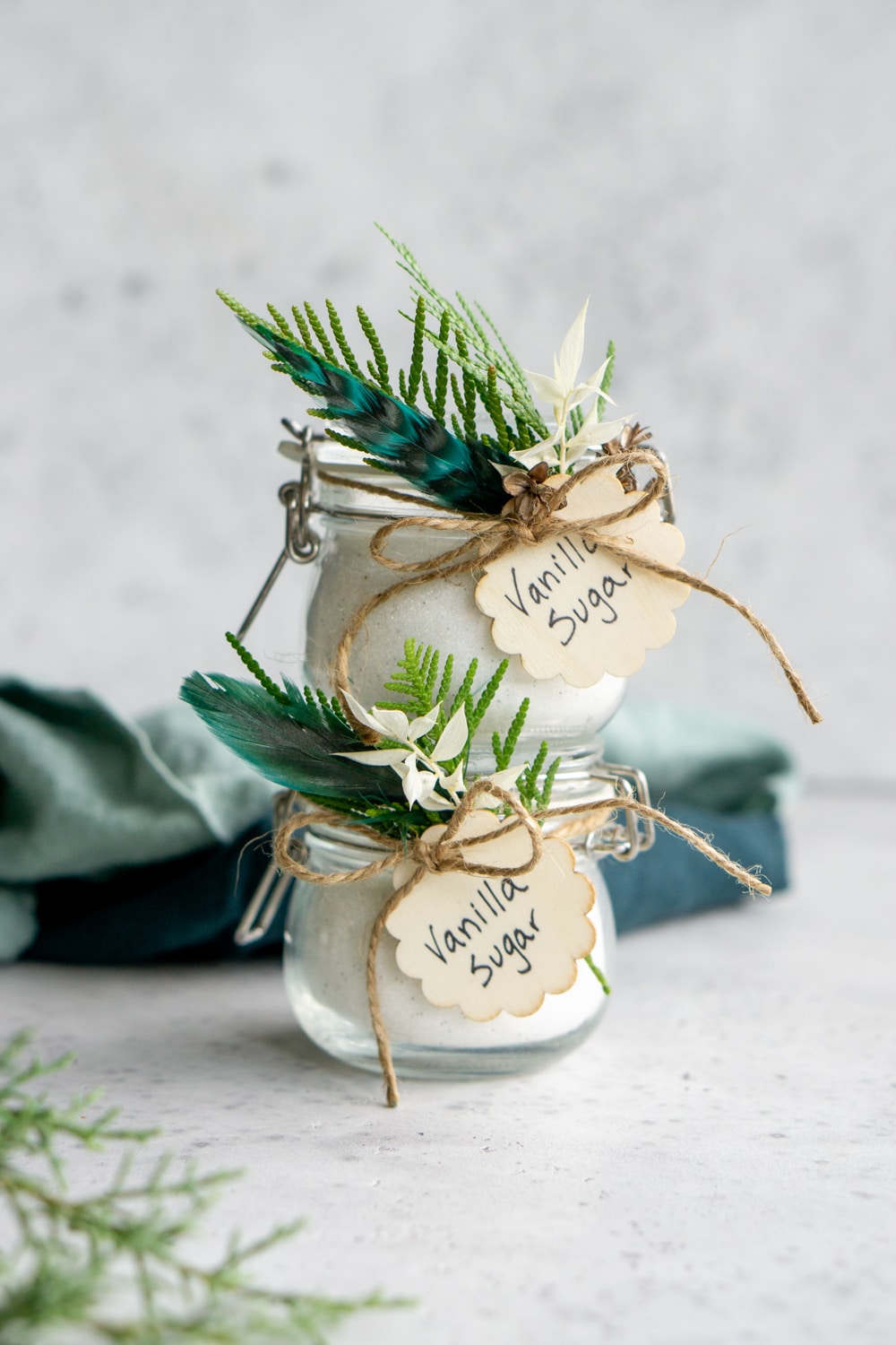 Two jars of vanilla stacked on each other with napkins in the background