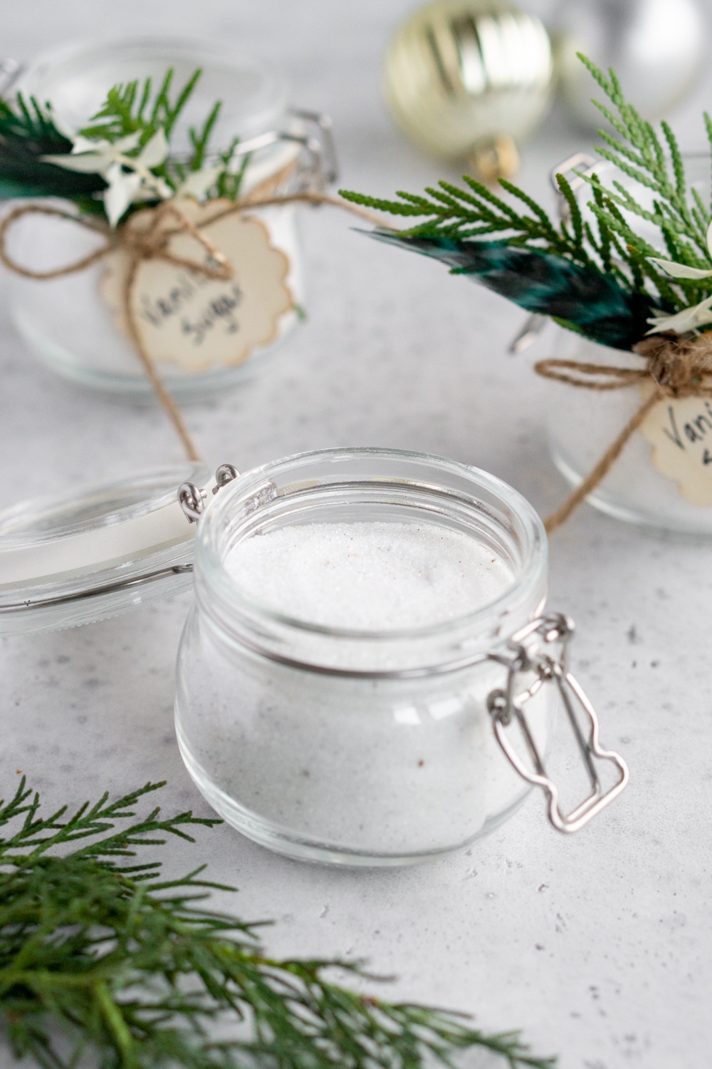 Jar of open vanilla sugar with two jars in the background