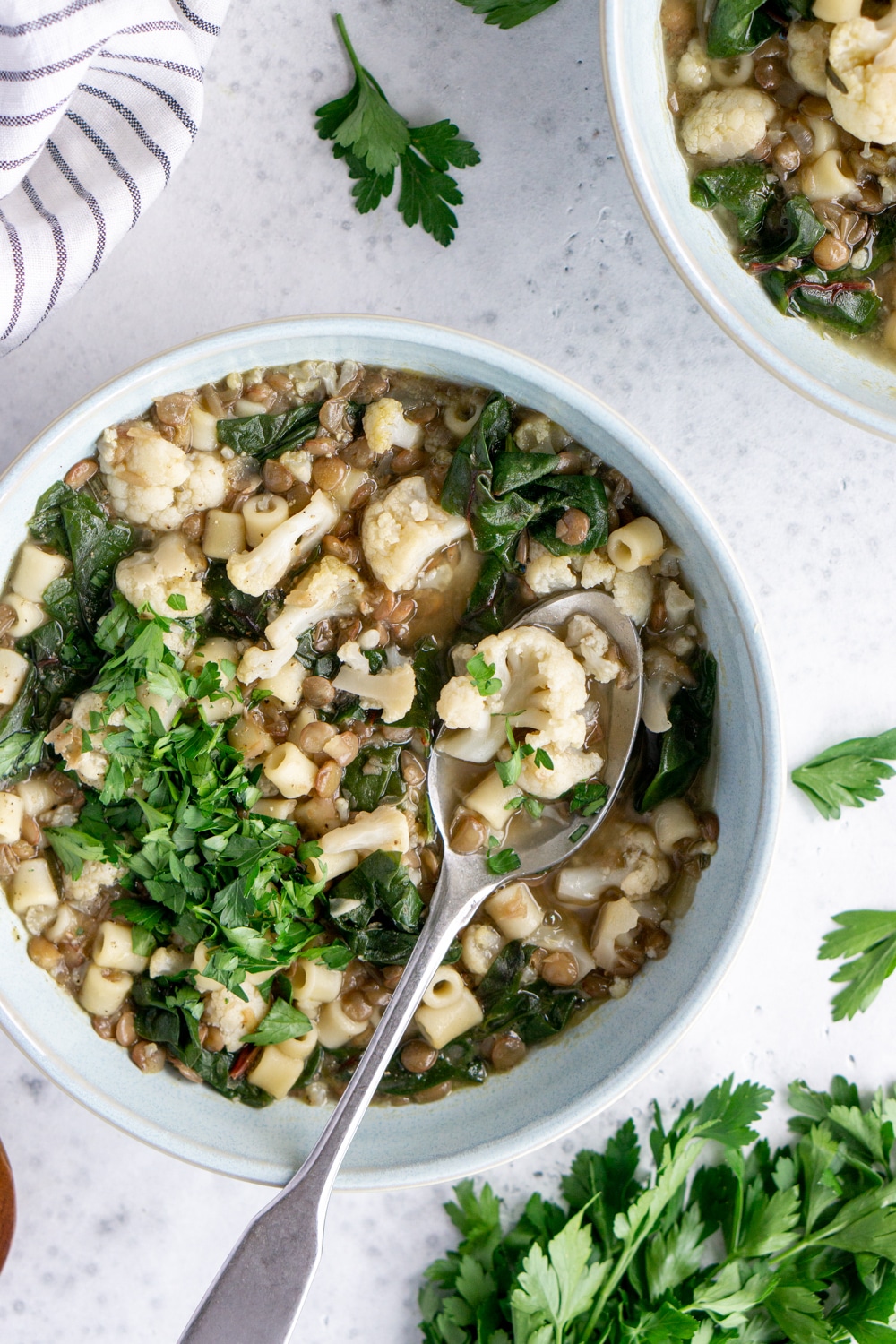Lentil soup in a blue bowl with a spoon in it