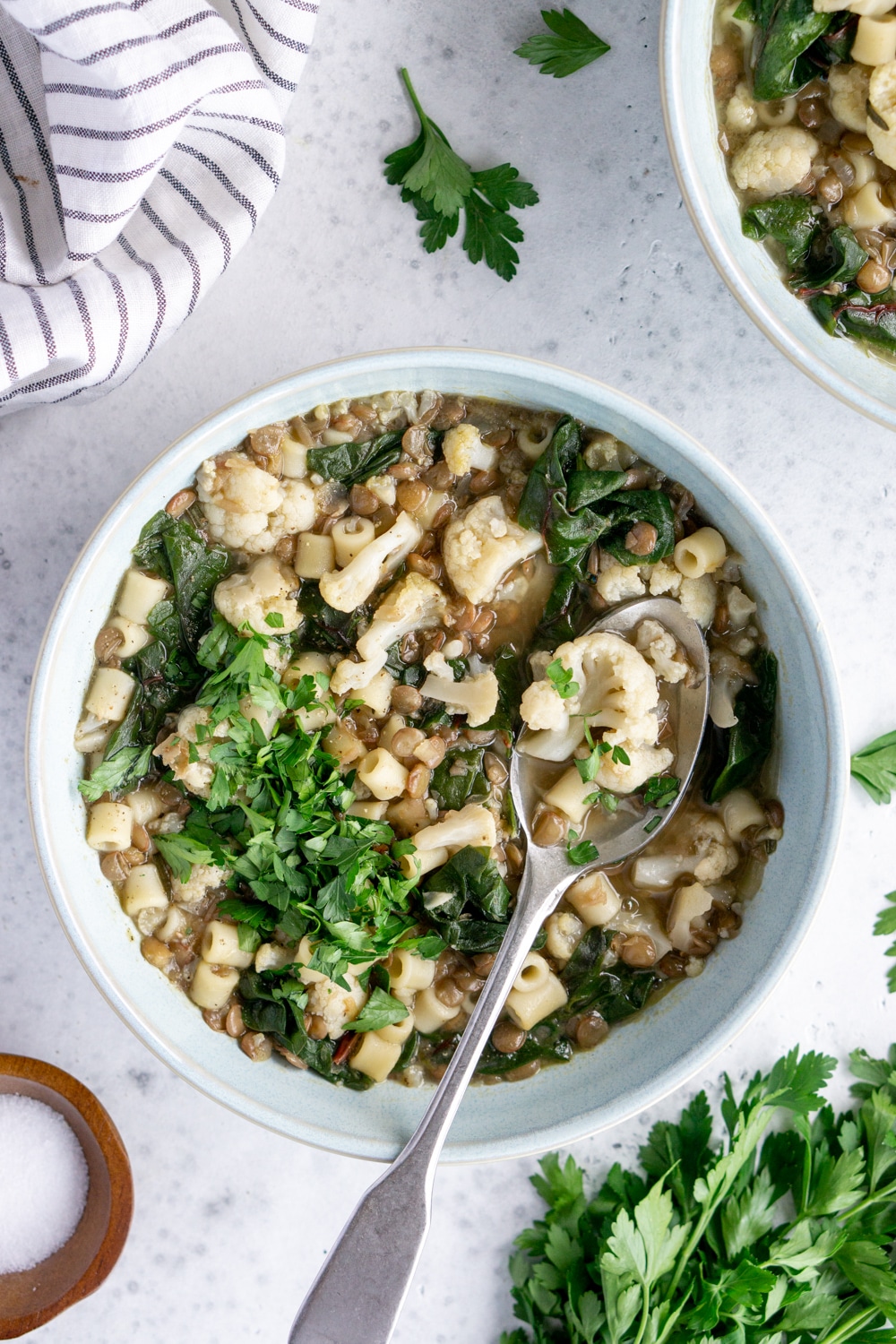 A beautiful vegan soup in a bowl made with lentils, cauliflower and swiss chard