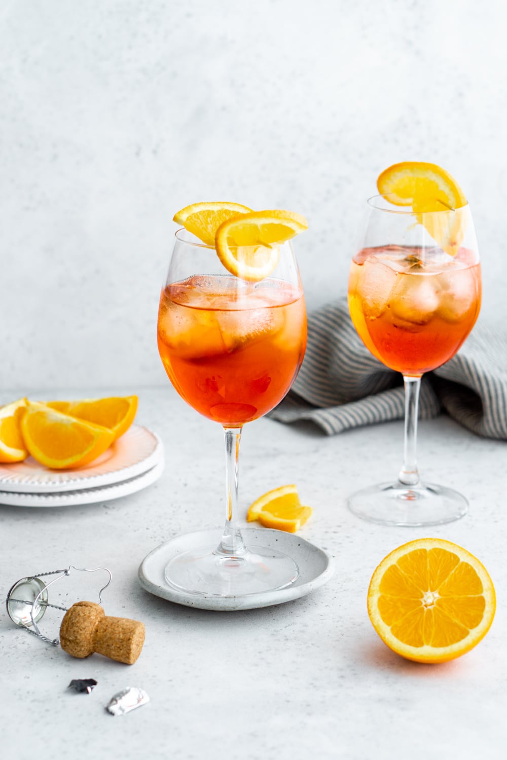 Aperol Spritz is a classic and refreshing Italian cocktail that you'll have on repeat! #aperolspritz #summercocktail #pinacooks 2 glasses of aperol spritz with oranges in the background