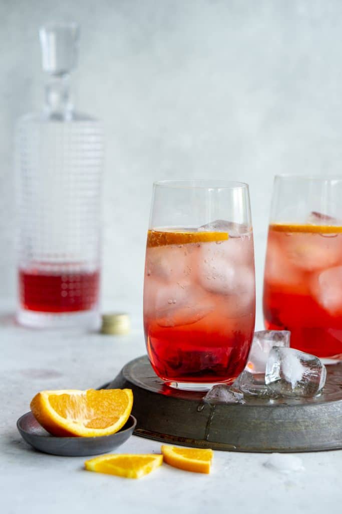 2 glasses of campari and soda on an inverted pie tin