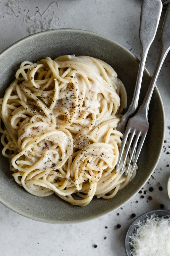Bowl of authentic cacio e pepe with 2 forks in it