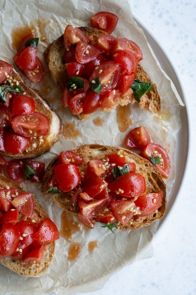 Four pieces of tomato bruschetta on a round plate