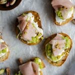 Burrata crostini with mortadella and a brown knife to the side