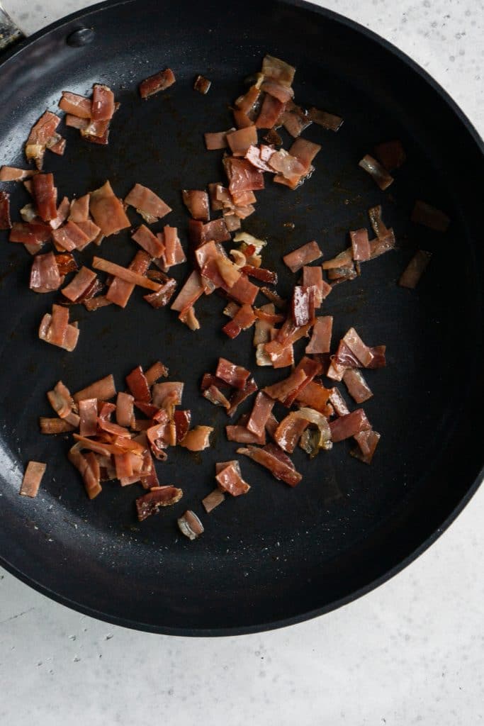 Strips of speck in a black pan