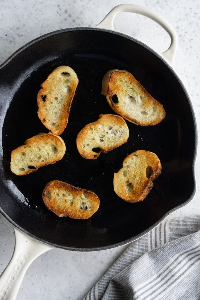 Crostini sauteed in olive oil in a cast iron pan