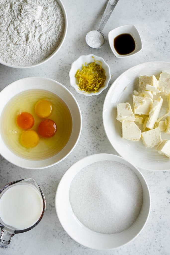 Ciambellone ingredients - eggs, flour, sugar, milk, lemon zest, vanilla extract, baking powder, granulated sugar