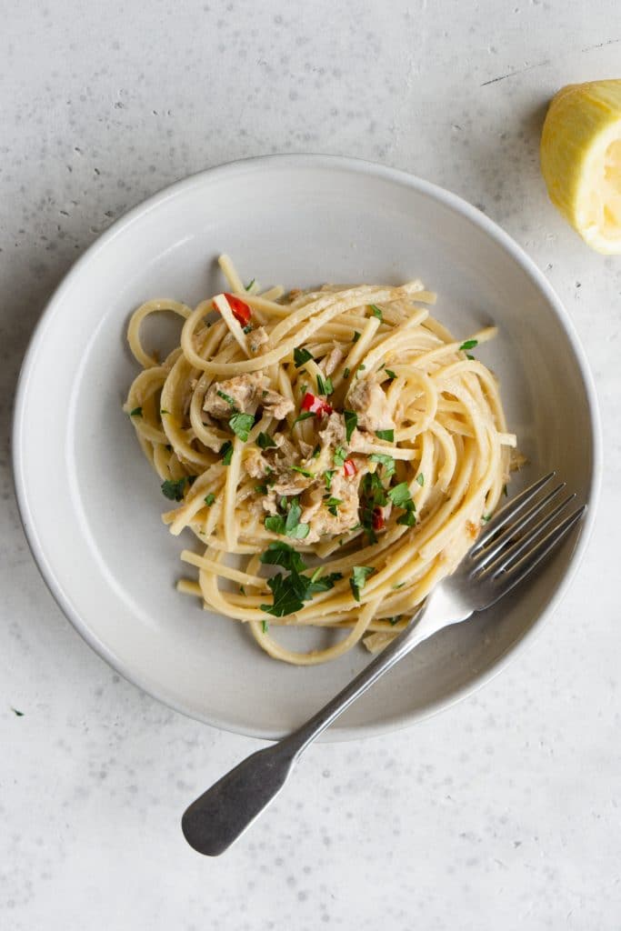 Tuna spaghetti in a plate topped with parsley