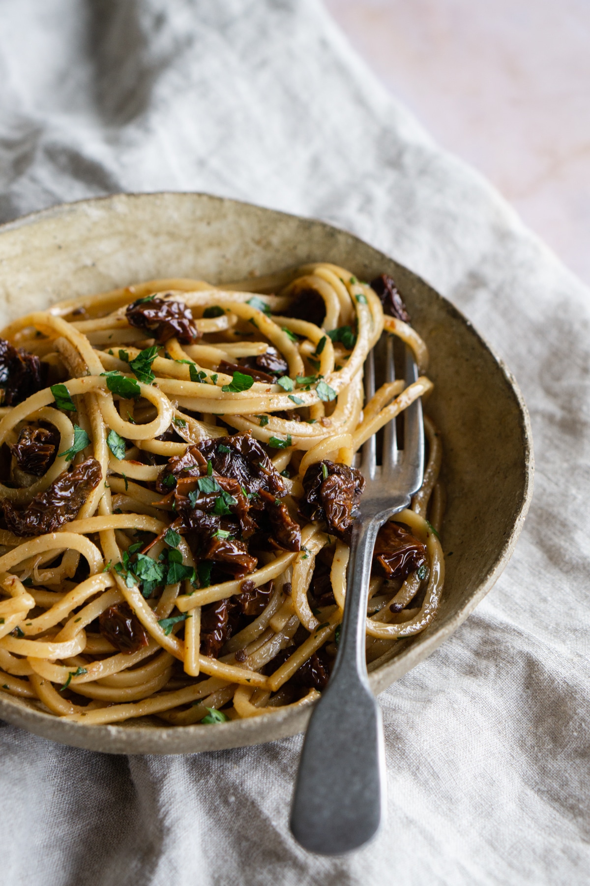 sun dried tomato spaghetti in a bowl topped with parsley