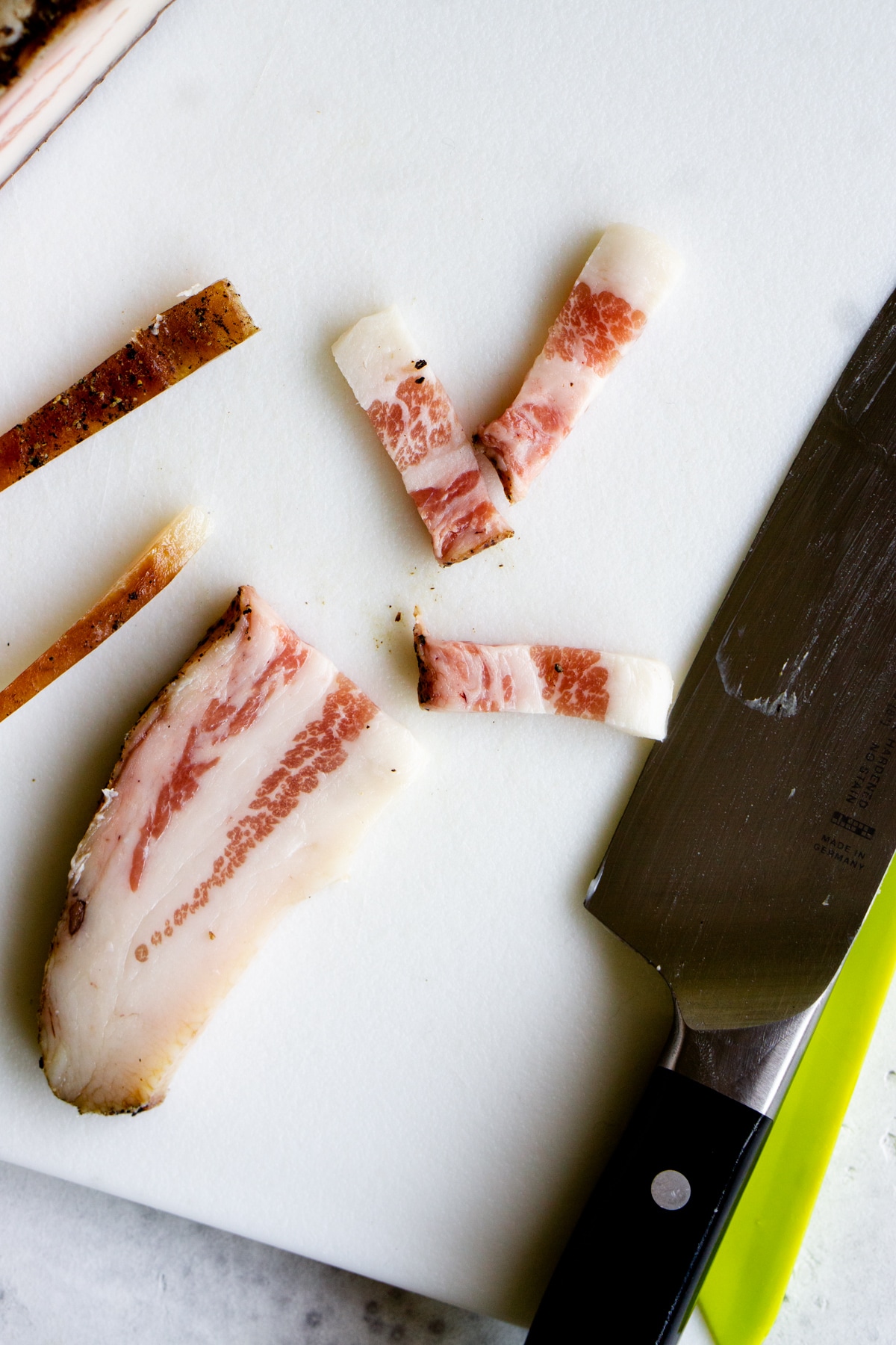 Guanciale cut into strips on a cutting board