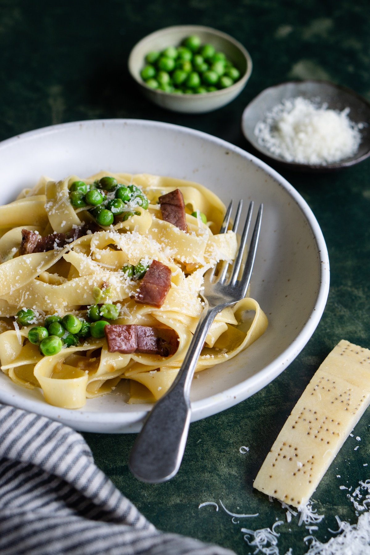 Side view of pasta alla papalina with two small bowls in the background