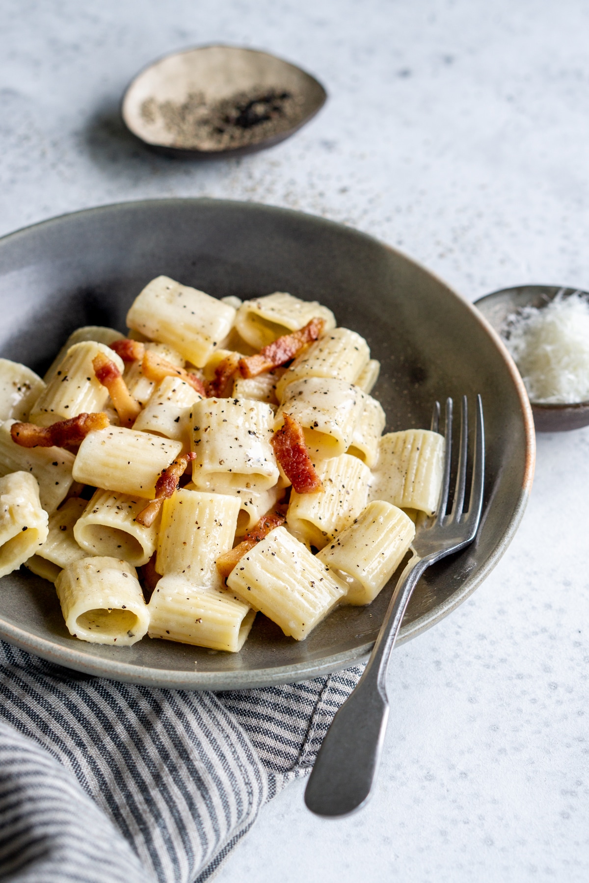 Pasta alla gricia topped with guanciale and black pepper in a bowl