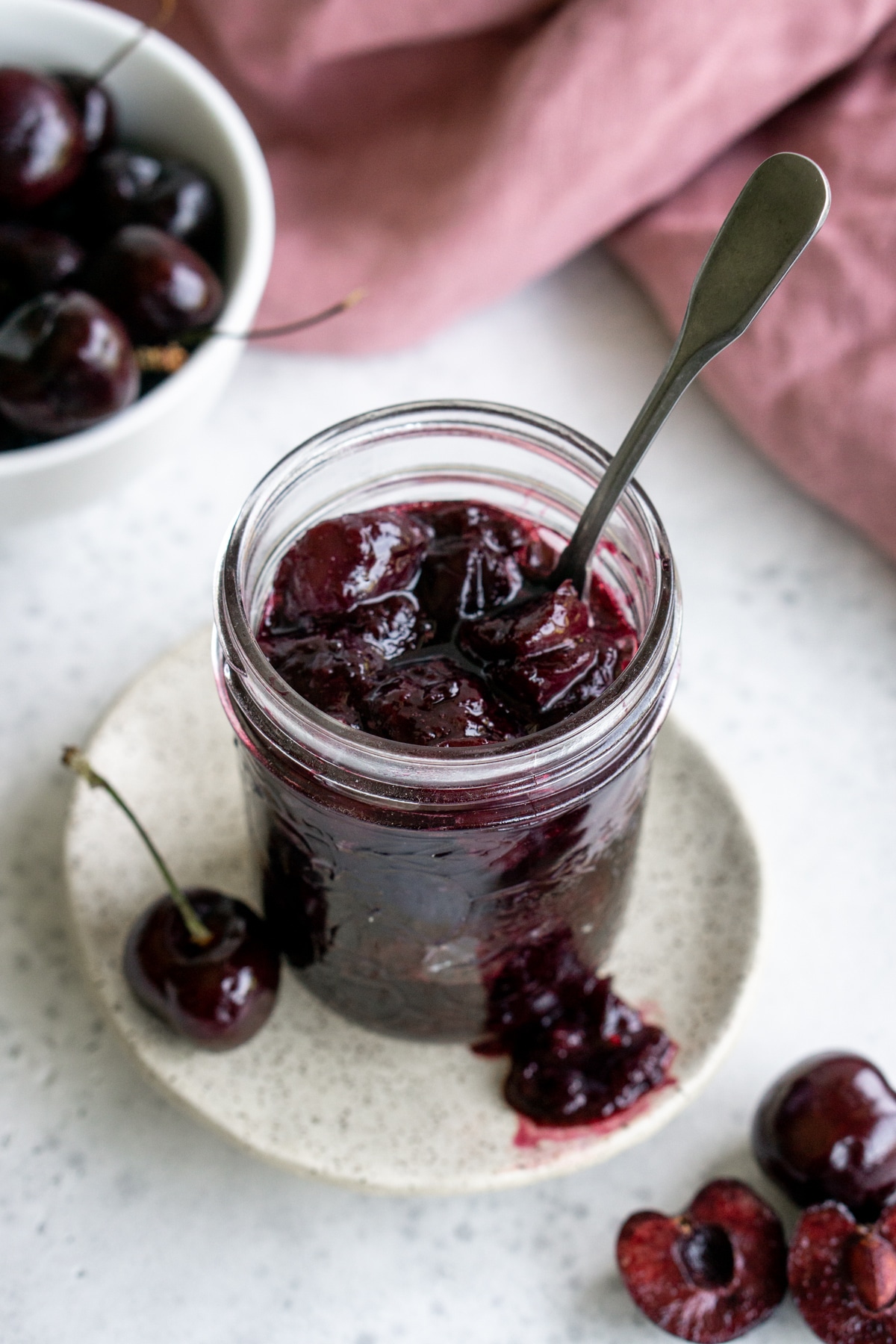 Jar of cherry sauce sitting on a small dish