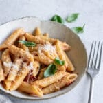 Tomato ricotta pasta in a plate topped with fresh basil