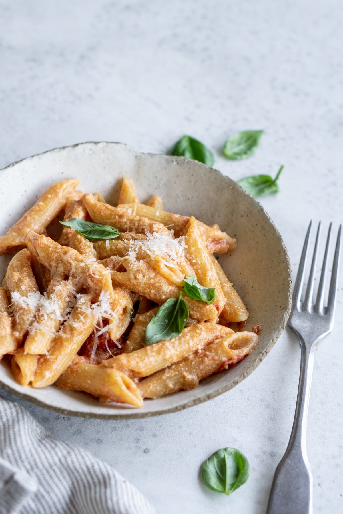 Tomato ricotta pasta in a plate topped with fresh basil