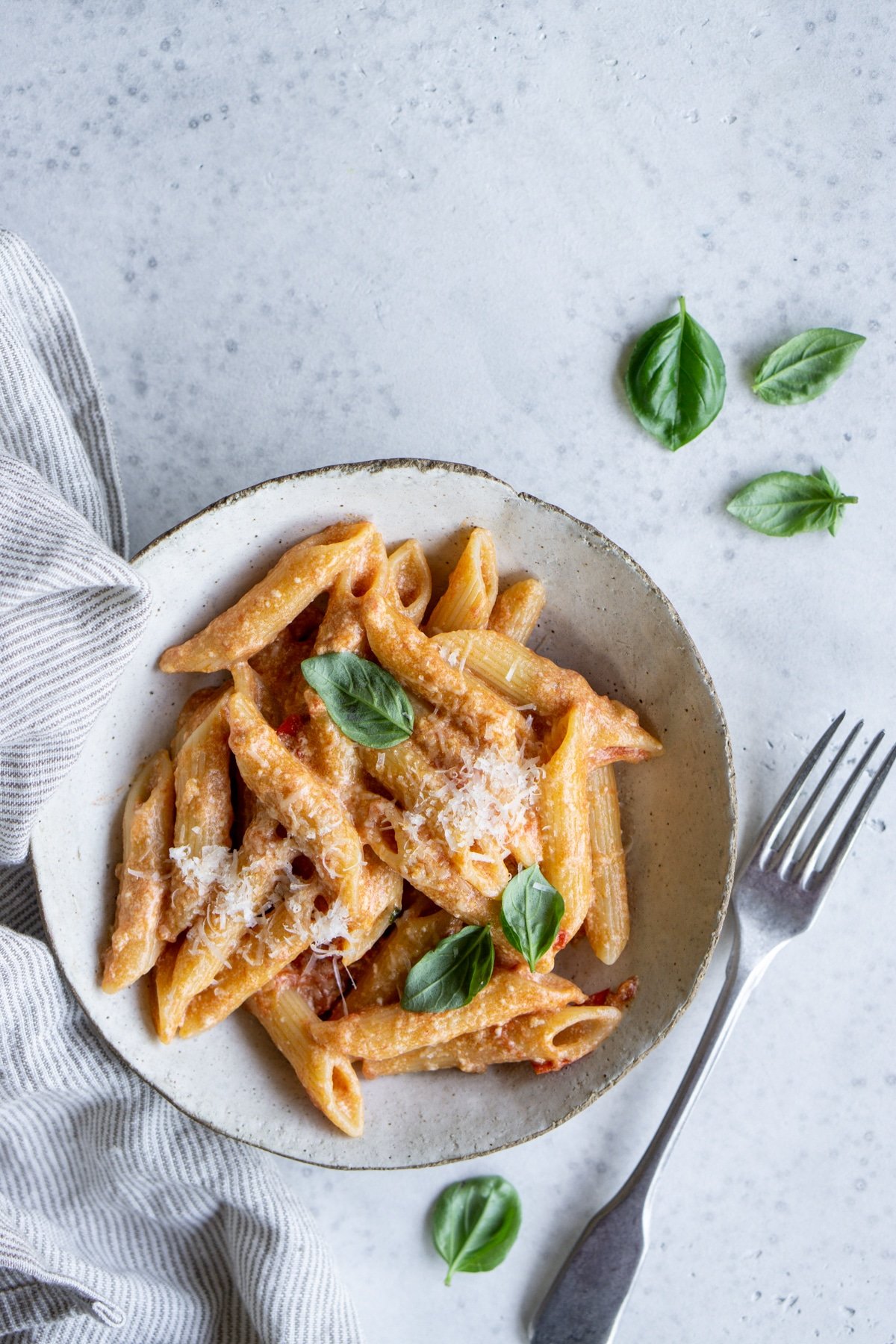 Bowl of tomato ricotta pasta with a napkin to the side