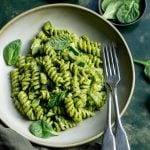 Plate of green goddess pasta with little bowls of zucchini and spinach in the background