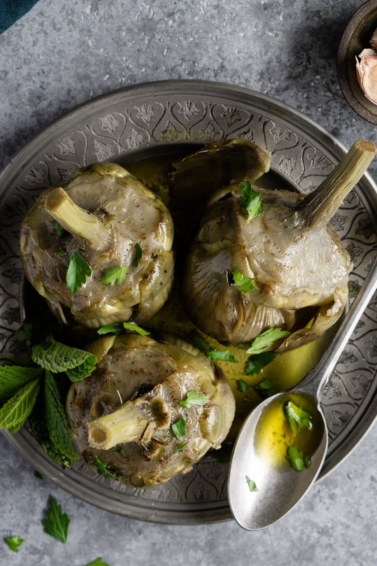 roman artichokes (carciofi alla romana) in a dish sprinkled with mint