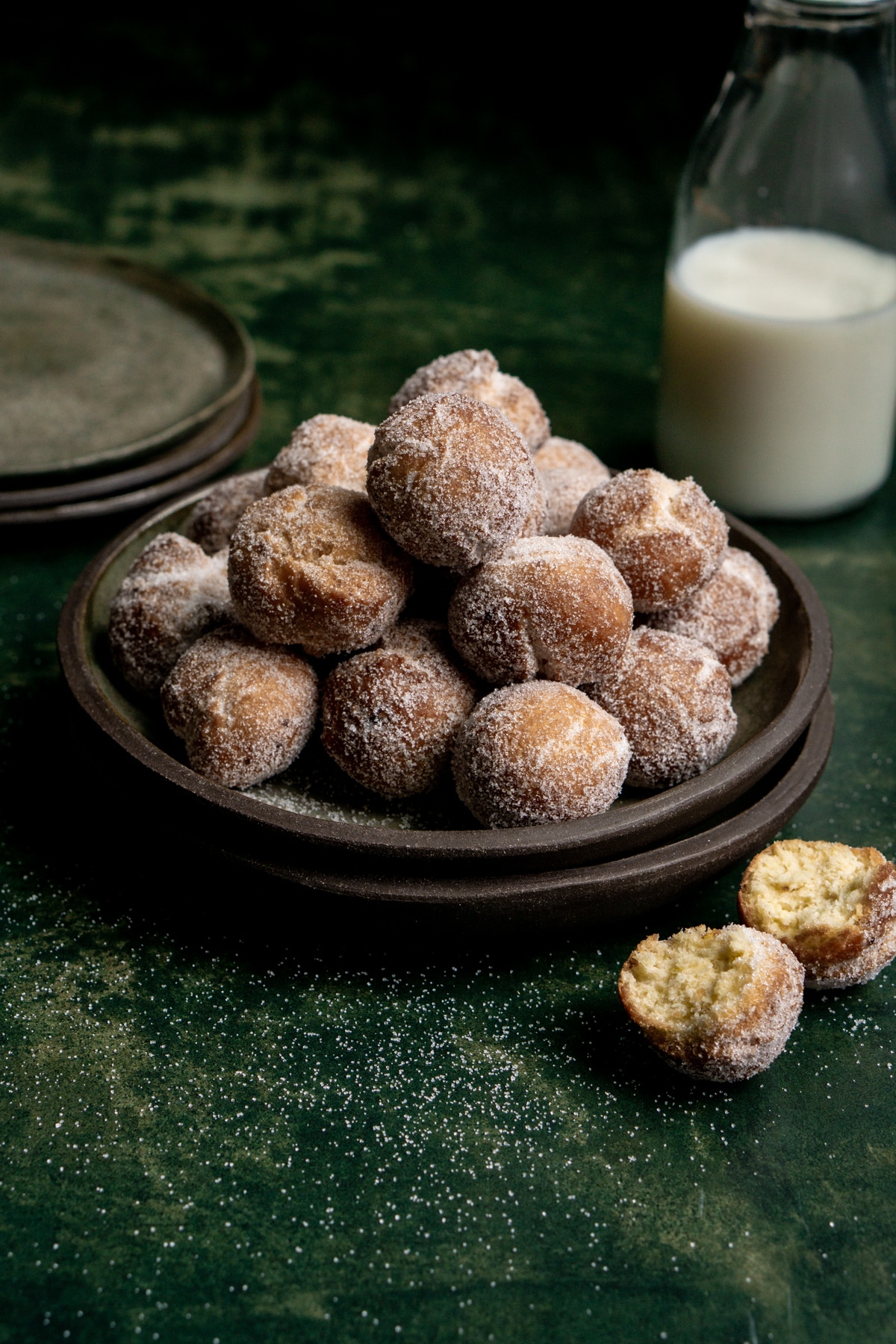 Castagnole in a plate with a stack of plates in the background
